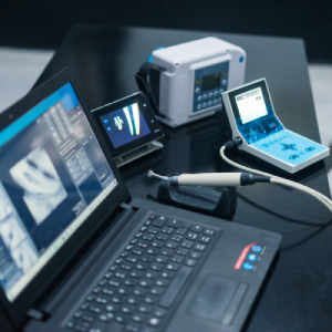 Computadora donde se visualizan los rayos x de un paciente endodóntico, a su lado vemos el aparato de rayos x portátiles, el motor de endodoncia y el localizador apical
